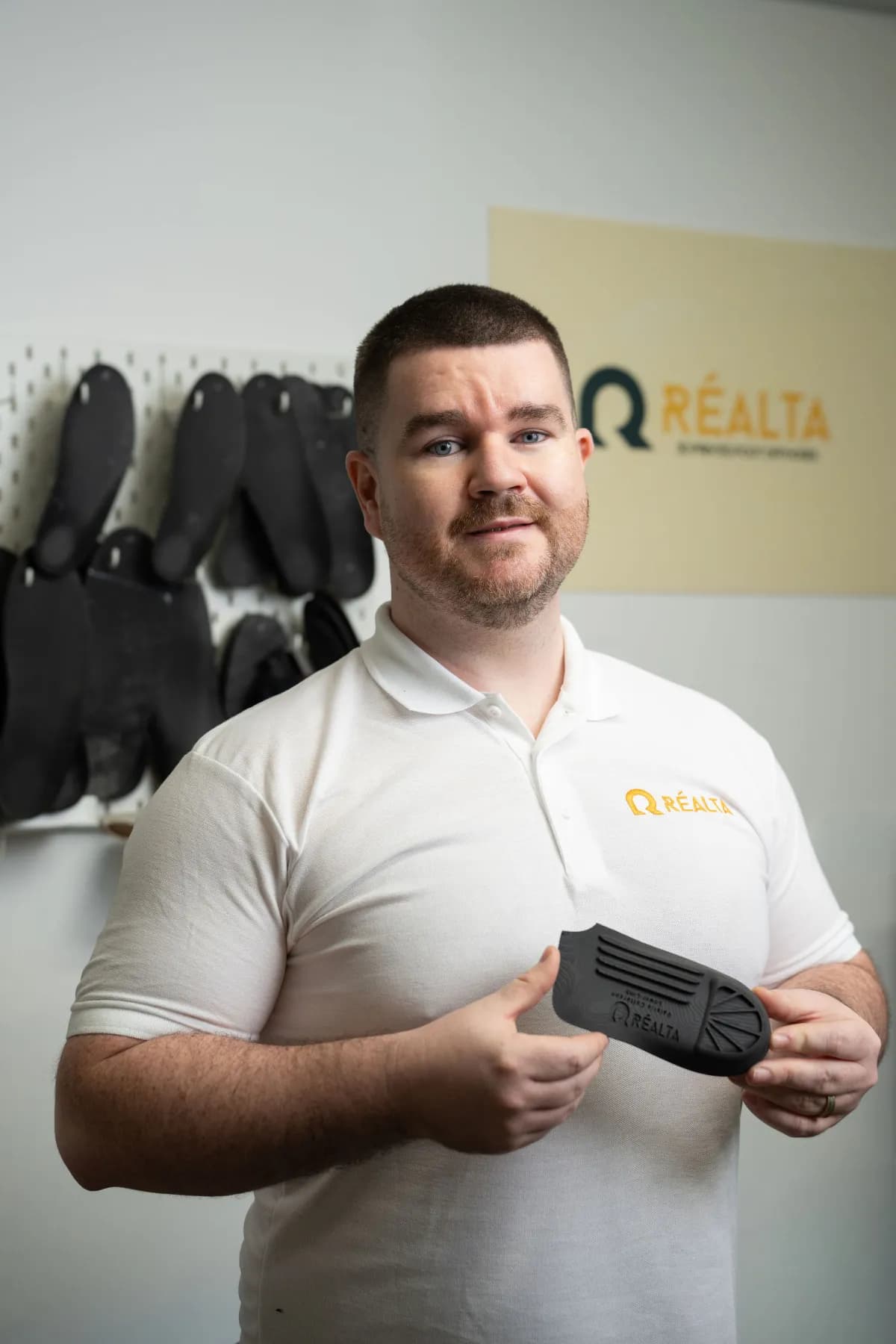 Paul McMullan holding Realta 3D printed orthotic